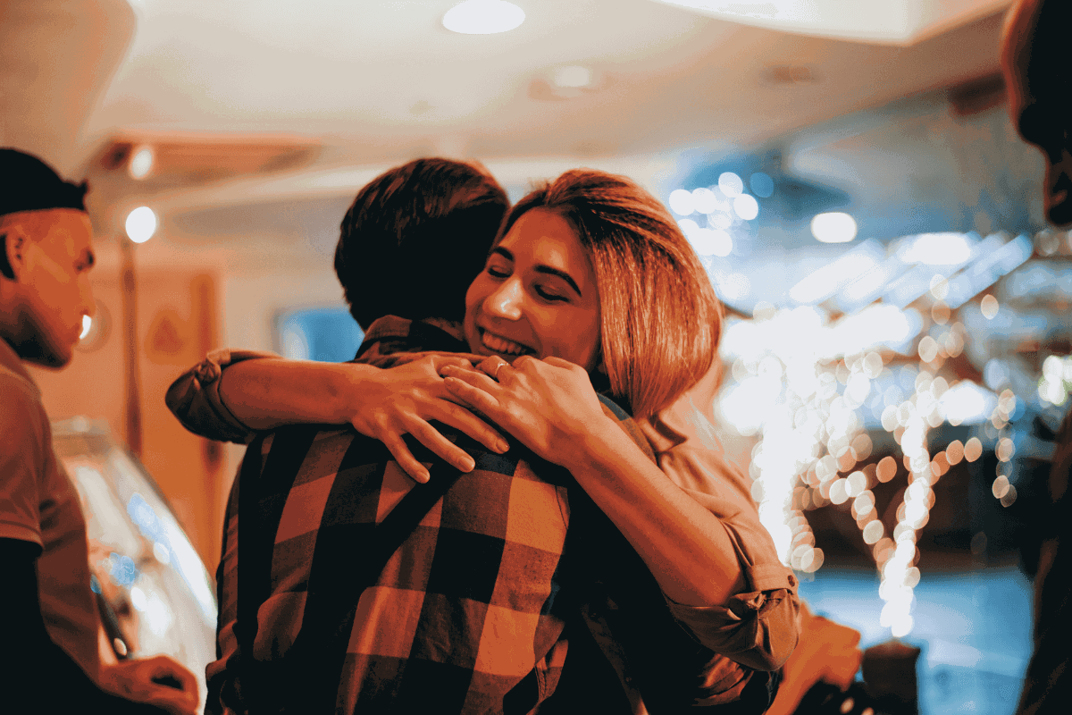 Woman hugging man, showing that touching and displays of affection is acceptable and common in Western cultures, but not so much in Eastern cultures.